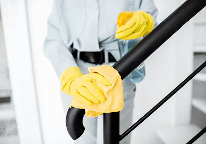 Pulizia del corrimano di una scala con panno in microfibra