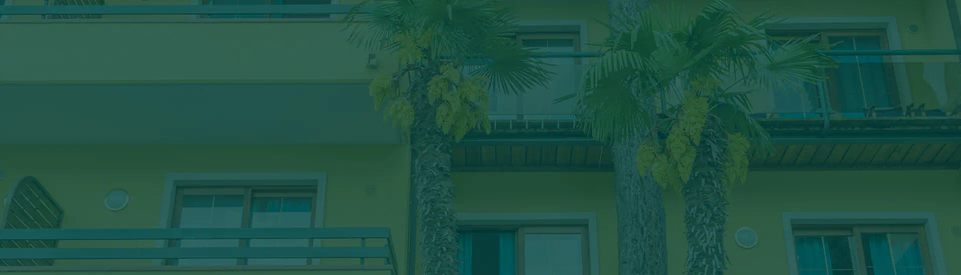 Facciata di un residence con palme e balconi