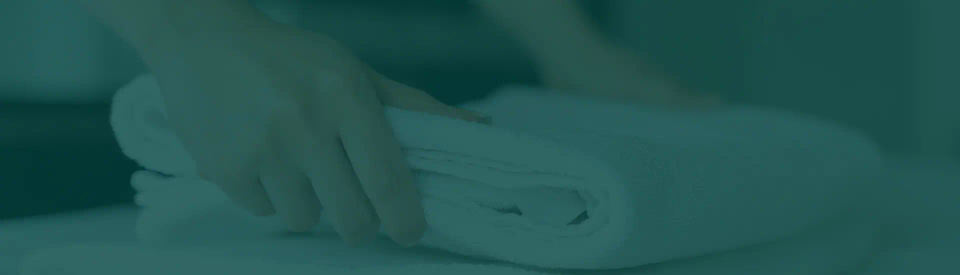 Asciugamano arrotolato sistemato su un letto
